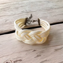 Krémszínű, csomózott karkötő